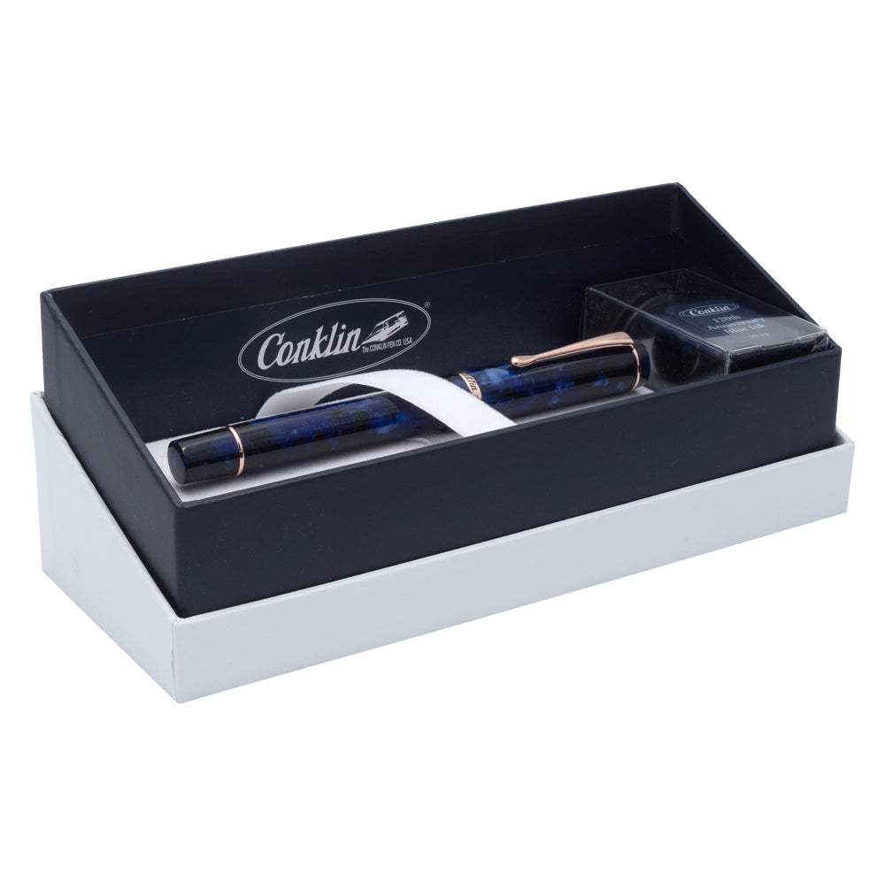 Un écrin ouvert contenant le stylo plume Conklin Duraflex 120 Ans et le flacon d'encre sont posés sur un fond blanc. L'écrin, avec son design sophistiqué et le logo de la marque, met en valeur l'édition spéciale du stylo pour le 120e anniversaire de Conklin.