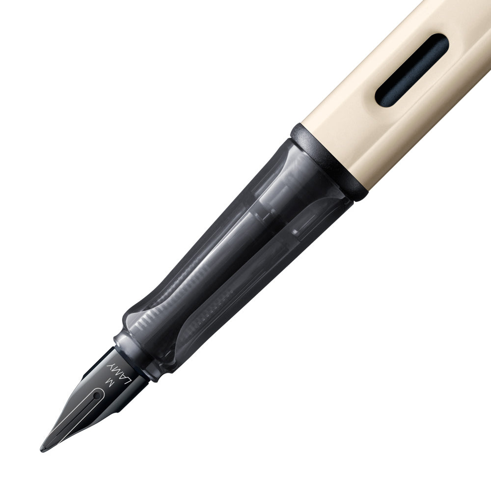 Gros plan sur la plume du stylo plume Lamy Crème LX Palladium. La plume en acier inoxydable de couleur noir est finement détaillée, offrant une écriture fluide et précise, tandis que la finition palladium et crème du stylo ajoute une touche d'élégance.