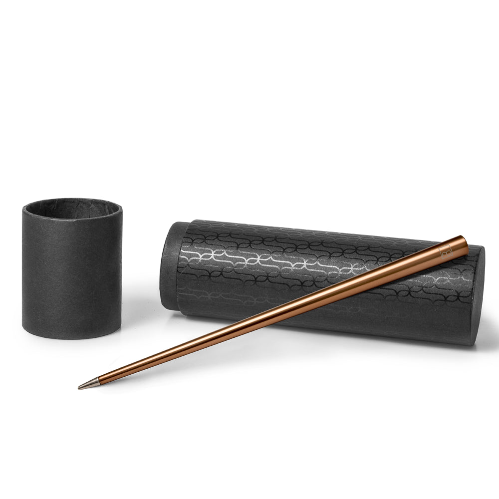 Stylo Forever Prima en cuivre posé sur son écrin cylindrique noir avec des motifs, présenté sur un fond blanc. L'écrin cylindrique protège le stylo tout en mettant en valeur sa couleur cuivre élégante et son design moderne.